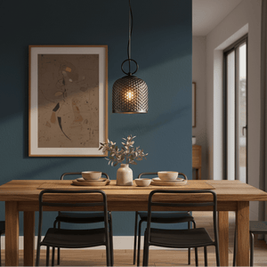 Chestnut Glass Pendant light hanging over a wooden dining table set with dishes and a vase.
