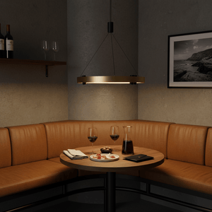 Black & Gold Monaco Round LED Pendant light hanging above a cozy dining table with wine glasses and food.