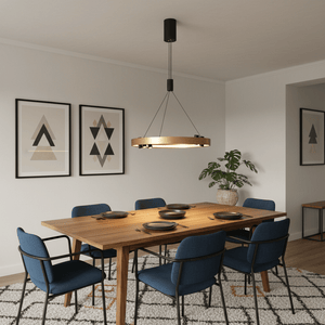 Black & Gold Monaco Round LED Pendant hanging over a wooden dining table set with plates, surrounded by blue chairs.