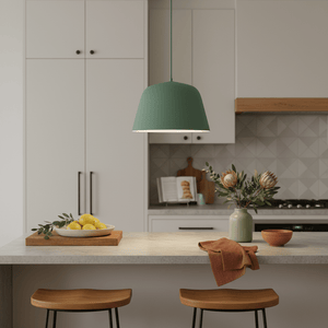 Teal pendant light hanging above a kitchen island with lemons and flowers on the counter.