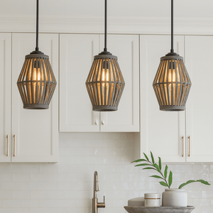 Three pendant lights hanging above a kitchen counter with cabinets and a plant in the background.