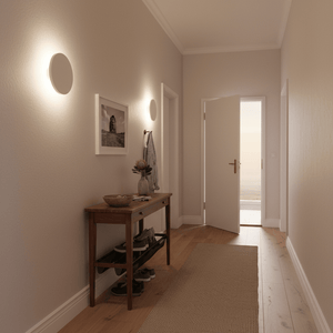 Stylish hallway featuring two round wall lights illuminating a wooden console table with decor.