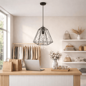 Black metal pendant light hanging above a wooden counter in a stylish indoor setting.
