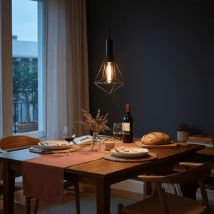 Black metal pendant light hanging above a dining table set with plates and wine glasses, creating a cozy atmosphere.