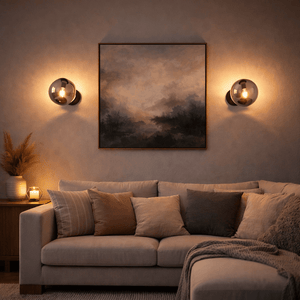 Bubble Glass Wall Light mounted beside a painting in a cozy living room setting, illuminating a sofa with soft light.