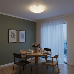 Dining room with a round table set for dinner under a polished chrome ceiling light.