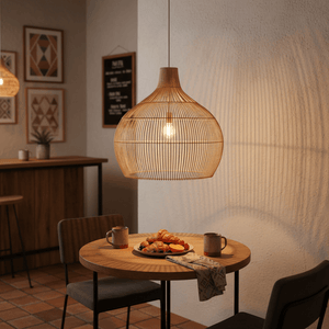 Woven bamboo rattan pendant light hanging above a dining table with food and drinks.