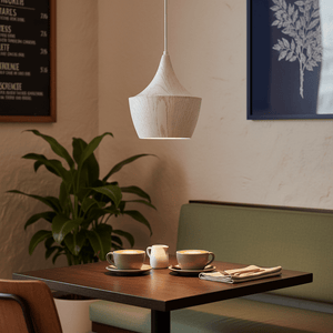 Ziggy White Wood Grain Pendant Light hanging above a cozy dining table with coffee cups and a plant.