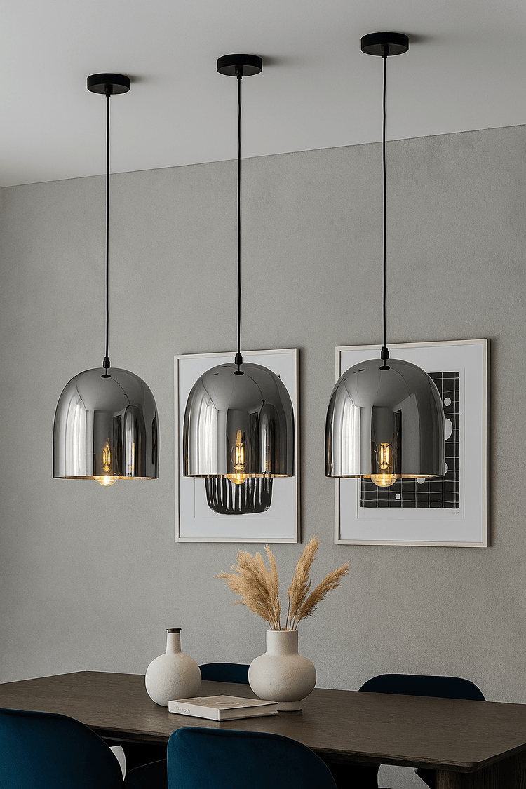 Modern interior with three hanging pendant lights, a table with decorative items, and framed artwork on the wall.