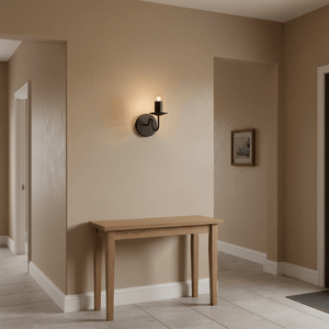 Harry Black Indoor Wall Light mounted on a beige wall beside a wooden console table, illuminating the space softly.