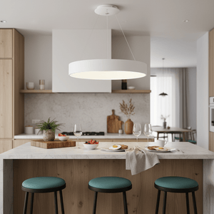 Modern LED pendant light hanging over a kitchen island with breakfast setup and green stools.