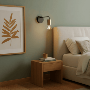 Traverse Indoor Wall Lamp mounted beside a bed, casting warm light on a wooden nightstand with decor.