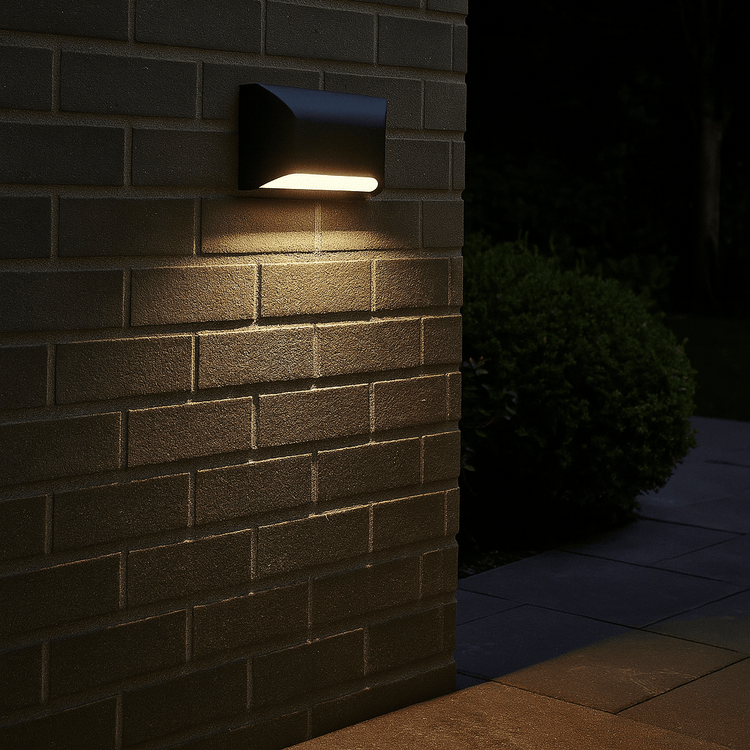 Outdoor wall light fixture on a brick wall at night