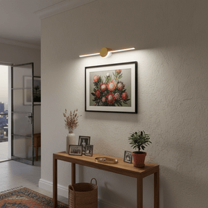 Gold slim LED linear light mounted above a framed floral artwork in a stylish indoor setting.