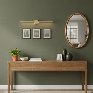 Gold slim LED linear wall light above a wooden console table with framed art and a round mirror.