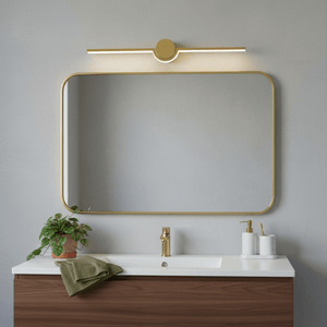 Gold slim LED linear light mounted above a rectangular mirror in a modern bathroom setting.