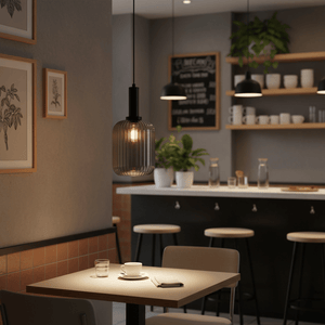 Athina Smoke Cut Glass Pendant light hanging over a dining table, creating a warm ambiance.