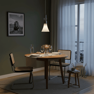 A modern dining setup featuring a white satin chrome pendant light above a round wooden table with two chairs.