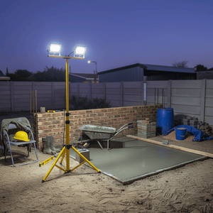 Construction site with a high-powered light tower illuminating the area, surrounded by construction materials and tools.