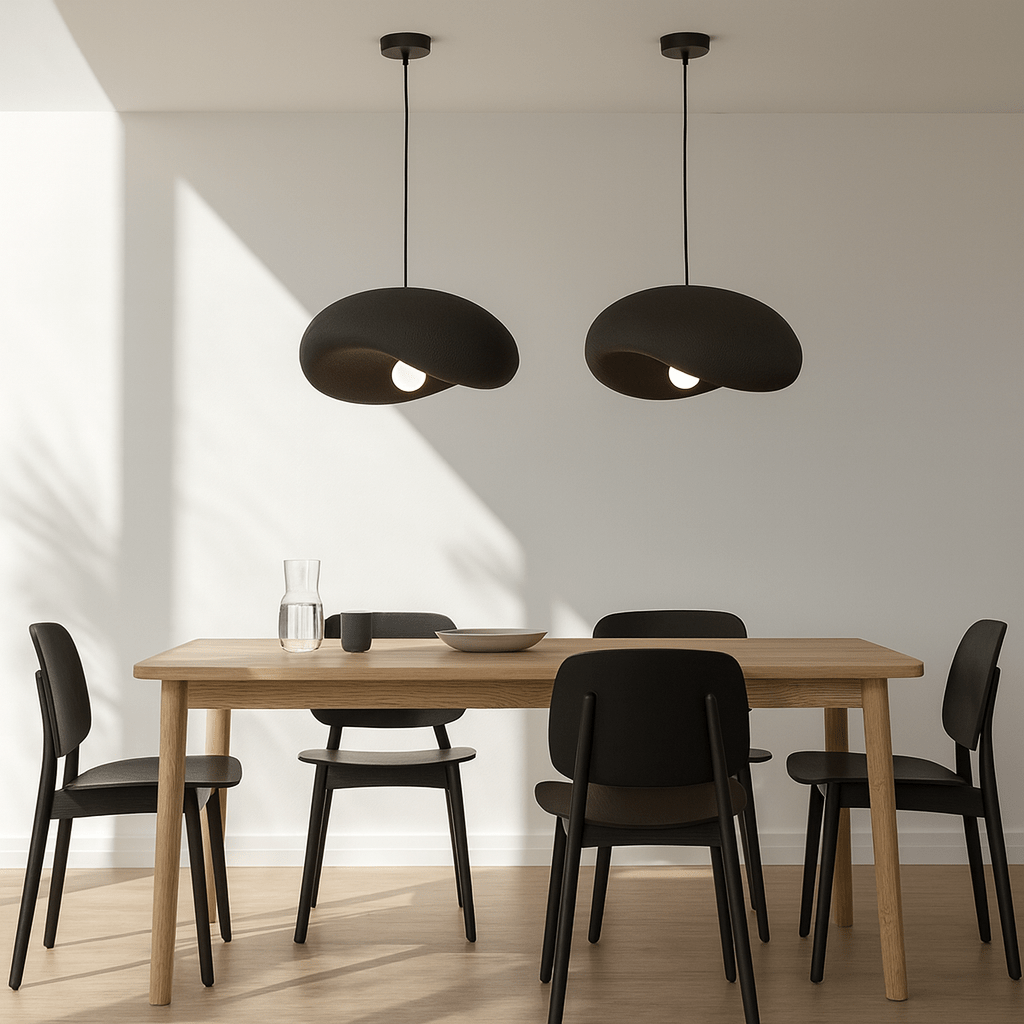 Two Obsidian Drift 500 Pendant Lights hang above a wooden dining table with black chairs, creating a modern ambiance.