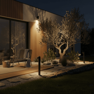 Outdoor scene with adjustable bollards lighting a garden path beside a modern house at night.