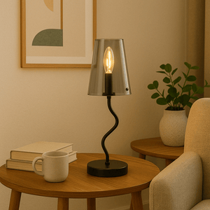 Calypso Smokey Table Lamp on a wooden side table with books and a mug, creating a cozy ambiance.