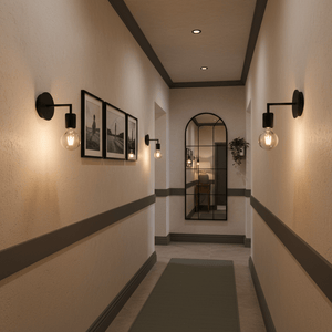 Black wall lights mounted along a hallway, illuminating framed photos and a mirror.
