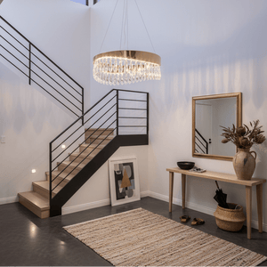 Elegant round chandelier with K9 crystals hanging in a modern foyer, illuminating a stylish entryway.