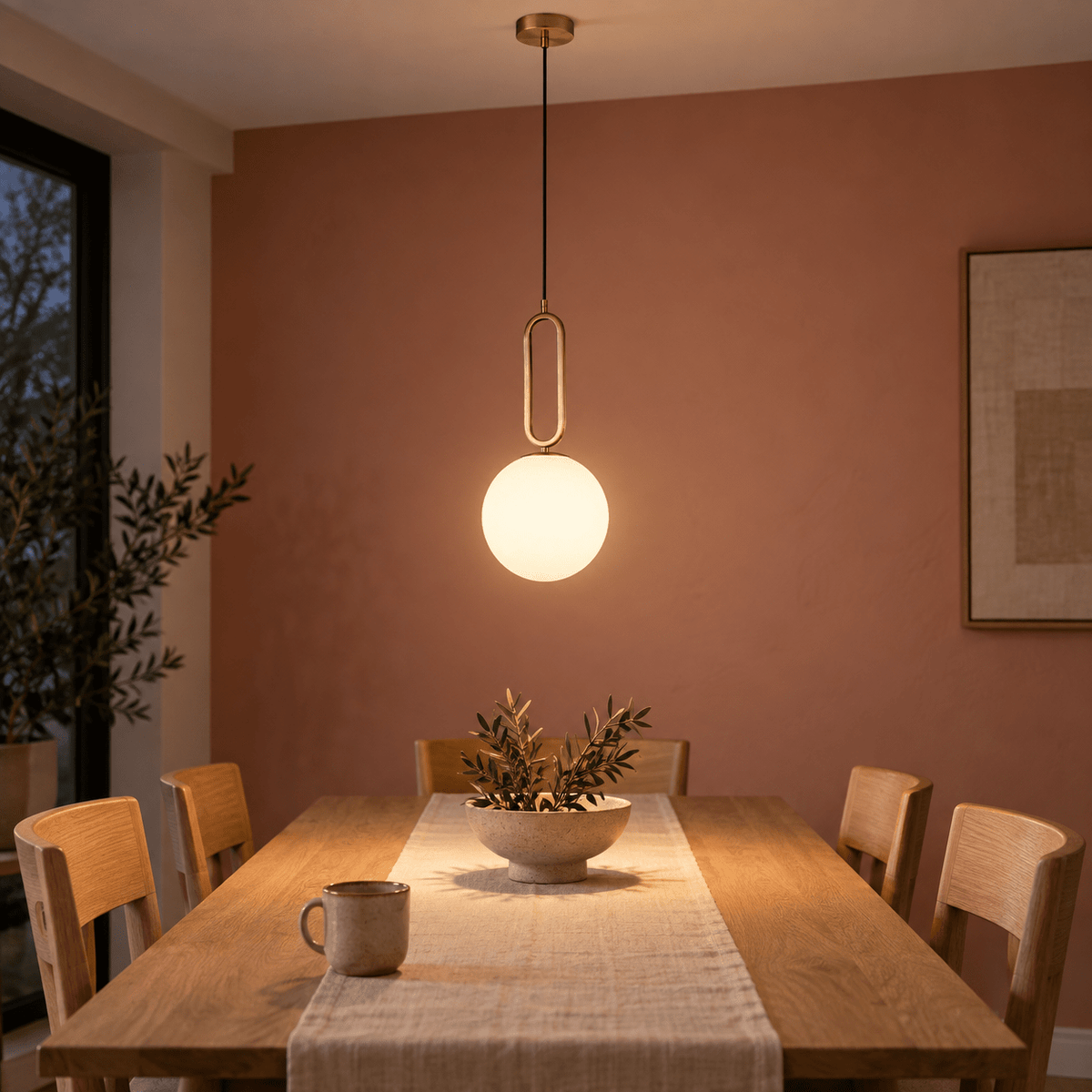 Croquet Medium Pendant Light — Dining table glow on a muted clay wall