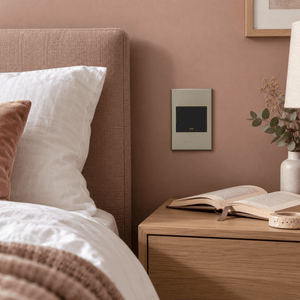 Veti 3 - One Lever, Two Way Light Switch - Graphite / Titanium lifestyle image: Bedroom bedside control, cabinet and muted clay-pink wall
