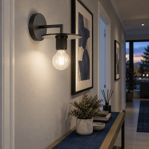 Trends Black Indoor Wall Light — Hallway artwork highlight, early dusk with warm indoor ambiance (still neutral-white lamp)