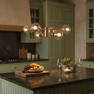 Gold and amber glass pendant light illuminating a kitchen island with fruit and wine glasses.