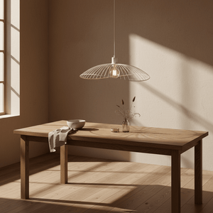 Stylish pendant light hanging above a wooden dining table with a bowl and decorative vase.