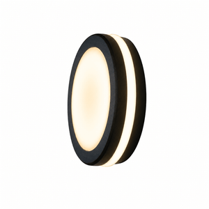 Close-up of a round black LED bulkhead light mounted on a textured wall, emitting a warm glow.