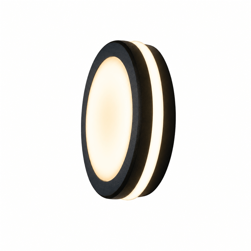 Close-up of a round black LED bulkhead light mounted on a textured wall, emitting a warm glow.