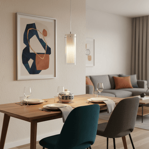 Double glass pendant light hanging above a wooden dining table set with plates and glasses, in a modern living space.
