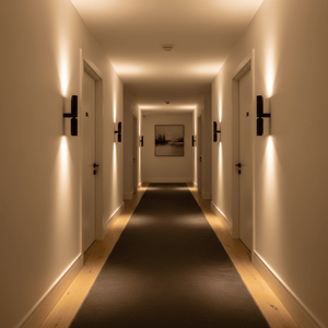 A well-lit hallway featuring the Banyan Black Up & Down Wall Light mounted on the walls, highlighting the space.