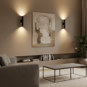 Banyan Black Up & Down Wall Light illuminating a textured wall with artwork, complemented by a modern living room setup.