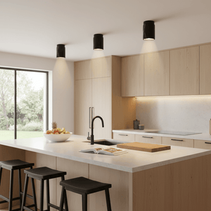 A modern kitchen featuring a black marble downlight holder, wooden cabinetry, a white countertop, and black stools.