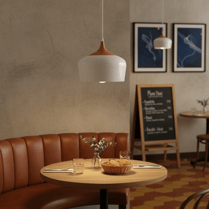 Scandinavian-style pendant light hanging above a cozy dining table with bread and greenery.