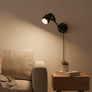 Indigo Mulberry wall lamp in matte black, illuminating a cozy living space with a sofa and side table.