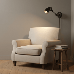 Indigo Mulberry wall lamp mounted above a cozy armchair, illuminating a small wooden side table with books.