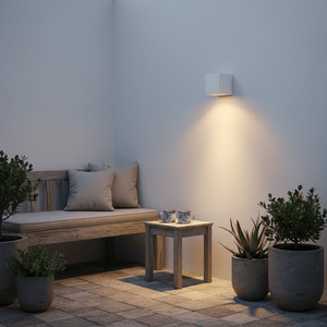 Stylish outdoor setting with a white wall light illuminating a wooden bench and potted plants.