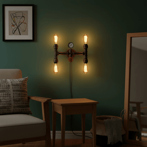 Industrial-style indoor wall light with four bulbs, mounted on a green wall beside a chair and table.