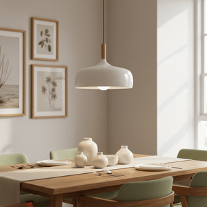 Scandinavian-style LED pendant light hanging above a wooden dining table set with plates and vases.