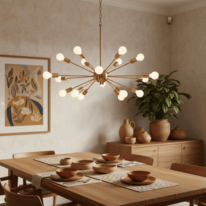 Satin gold pendant light hanging above a wooden dining table set with bowls and a decorative plant in the background.