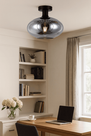 Smokey orb ceiling light mounted in a cozy room with a wooden table, bookshelves, and a vase of flowers.