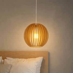 Wooden pendant light hanging above a bed with neutral wall background