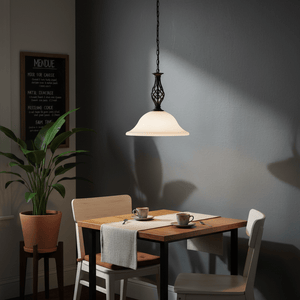 Black metal pendant light with alabaster glass shade hanging over a dining table set for two.