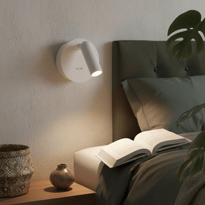 Rechargeable LED bedside wall light mounted beside a bed, illuminating an open book on a nightstand.